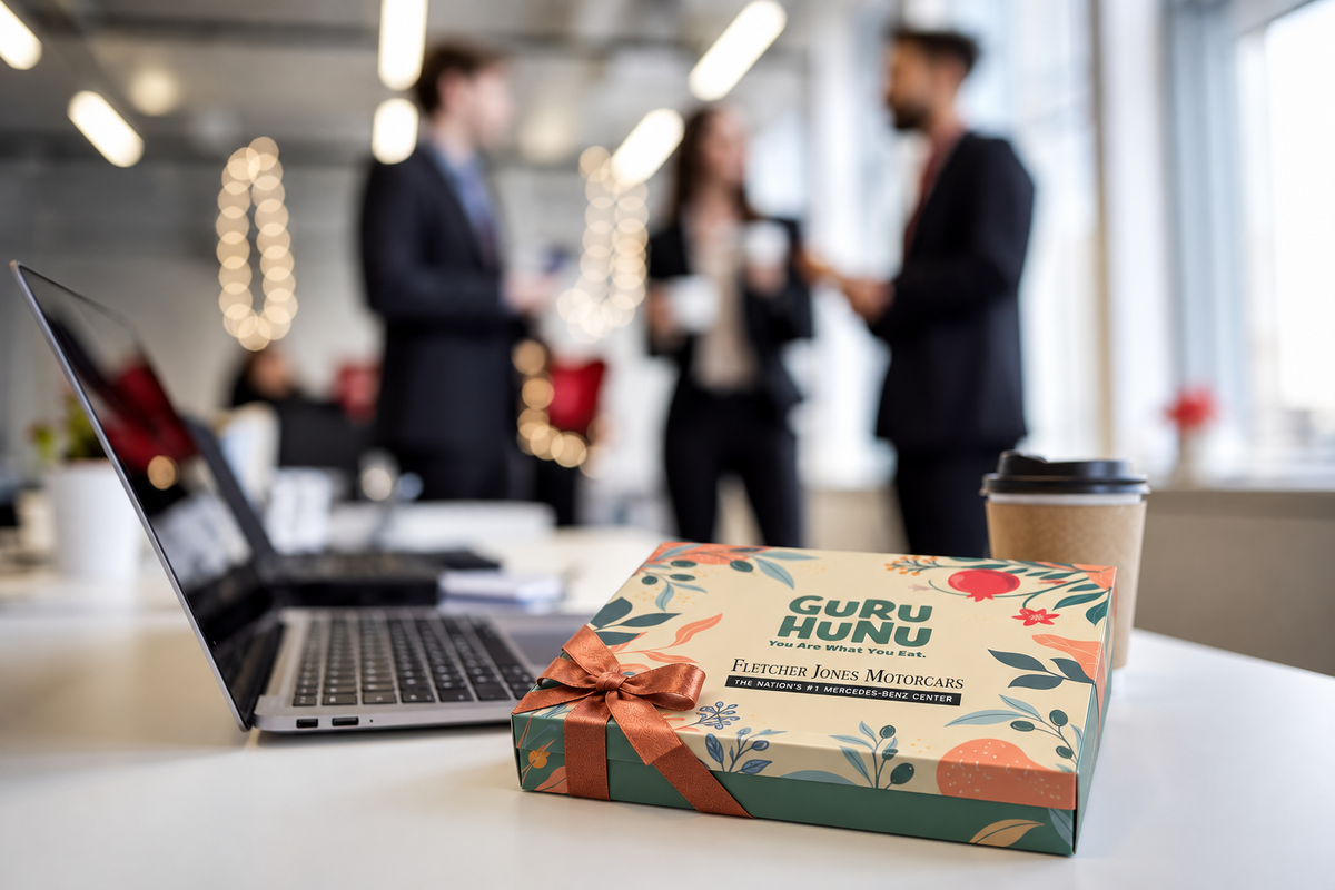 Illustrative photo composite: personalized Guru Hunu gift box with fletcher jones logo in an office gifting scene.